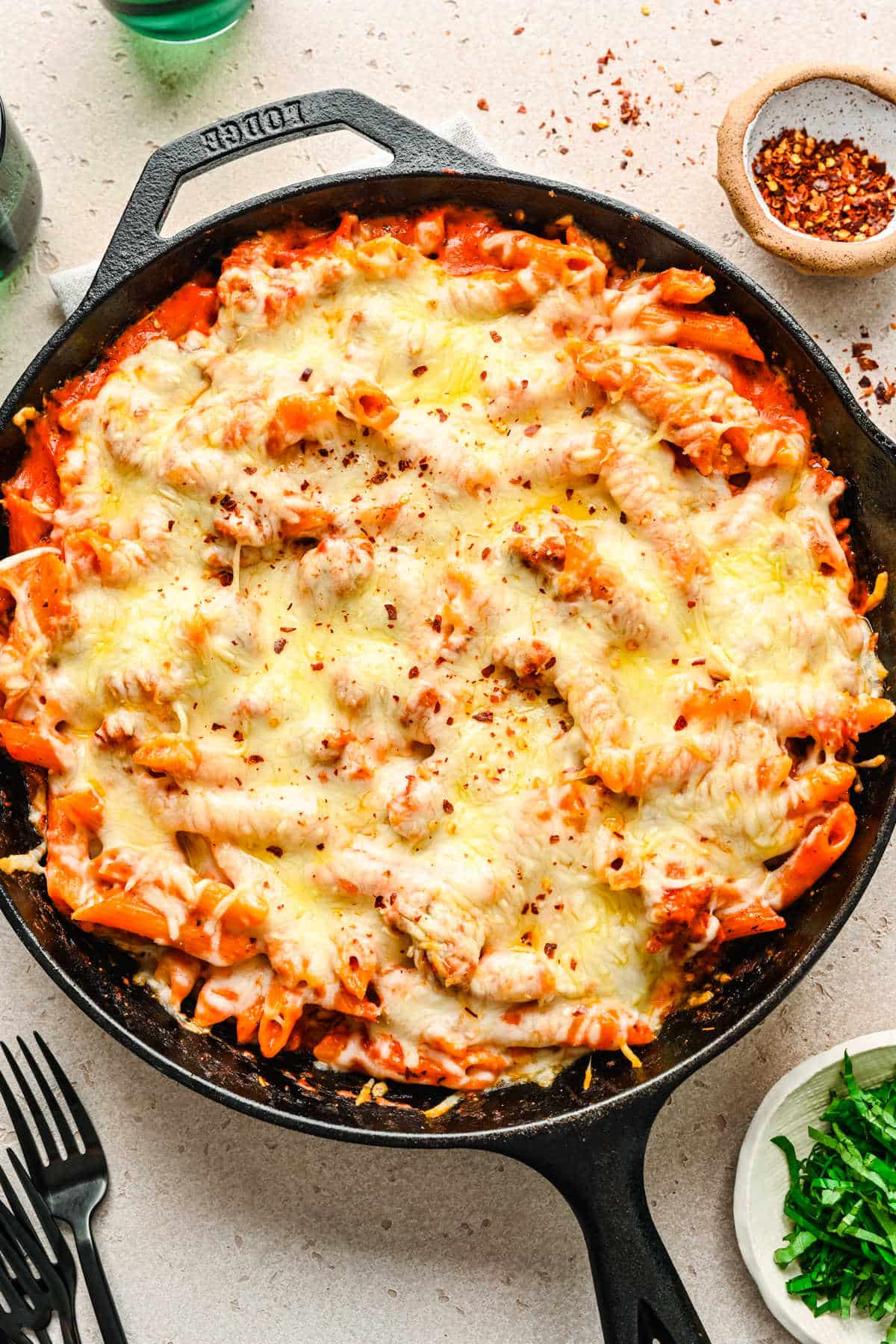 Melted cheese on top of baked ziti in a cast iron skillet.