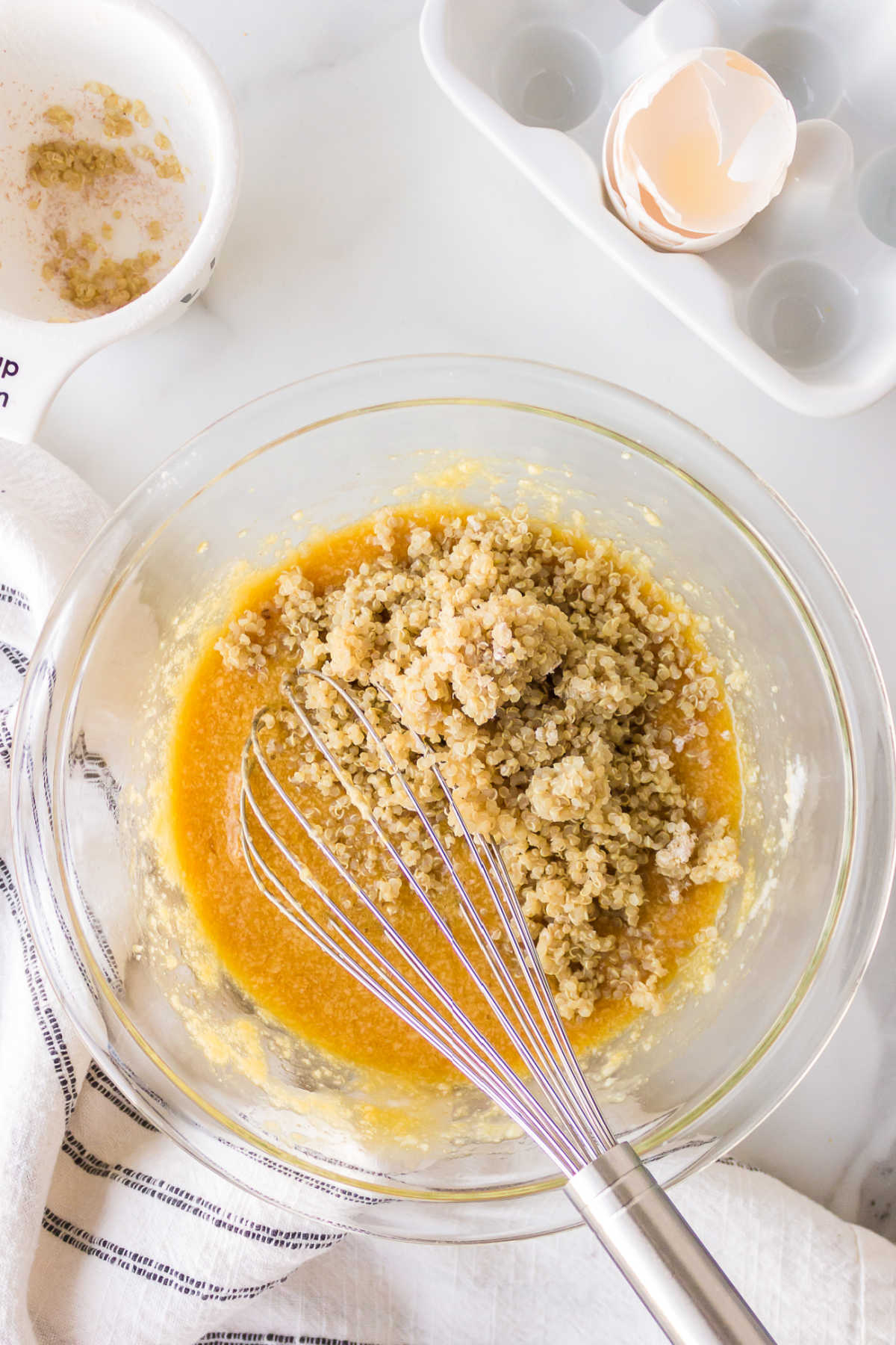 Cooked quinoa on brown sugar mixture in glass mixing bowl. 