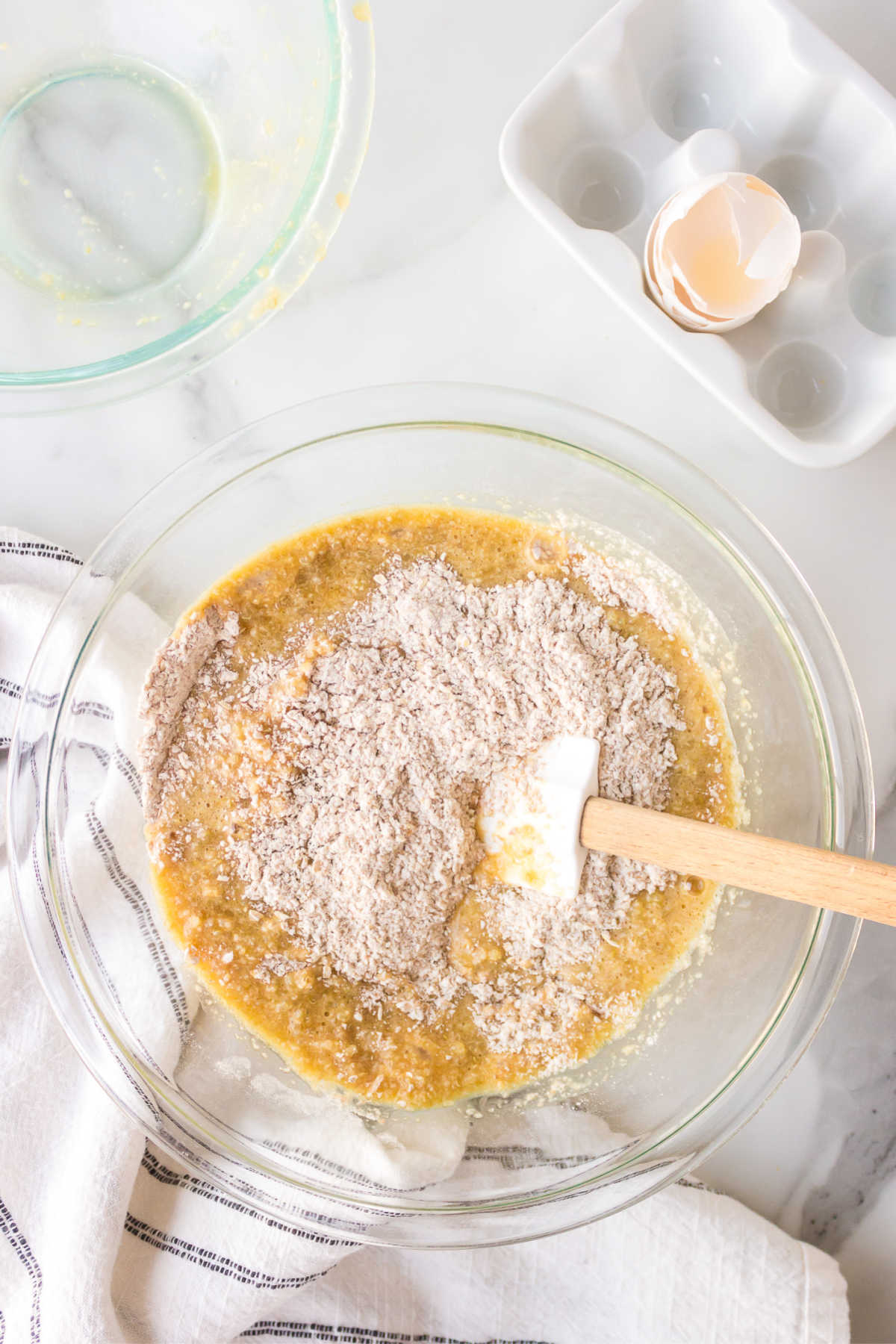 A spatula stirring dry ingredients into wet ingredients for quinoa cookies. 