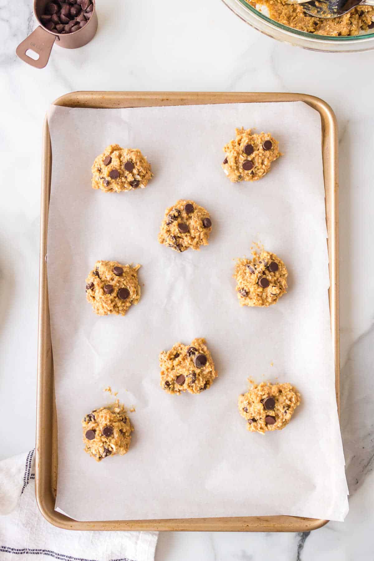 Scoops of quinoa cookie dough on a baking sheet. 