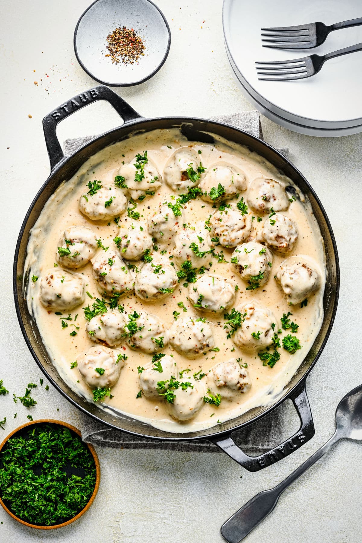 A cast iron pan filled with Swedish meatballs and cream sauce.