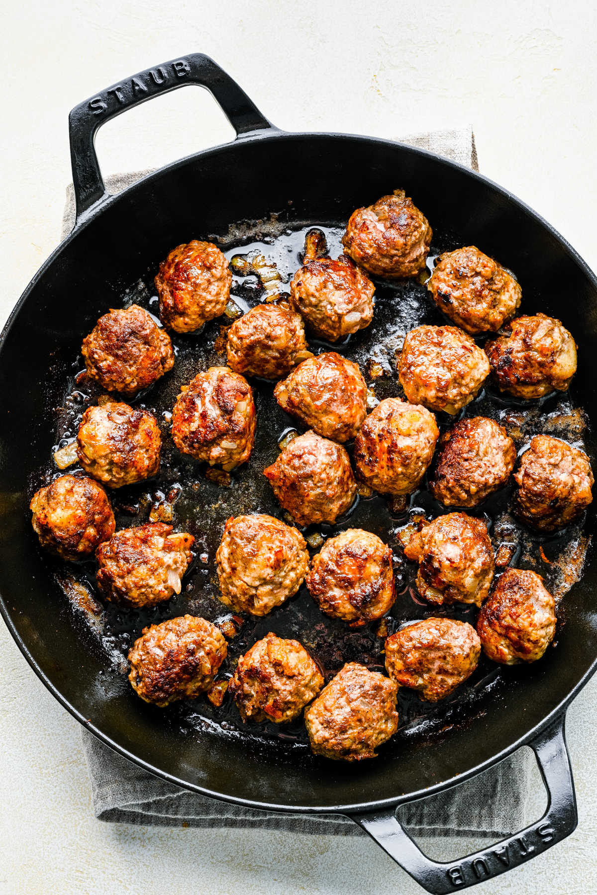 Browned Swedish meatballs in a cast iron skillet. 