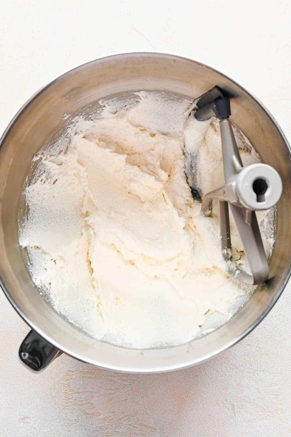 Butter and oil beaten together in a silver mixing bowl.