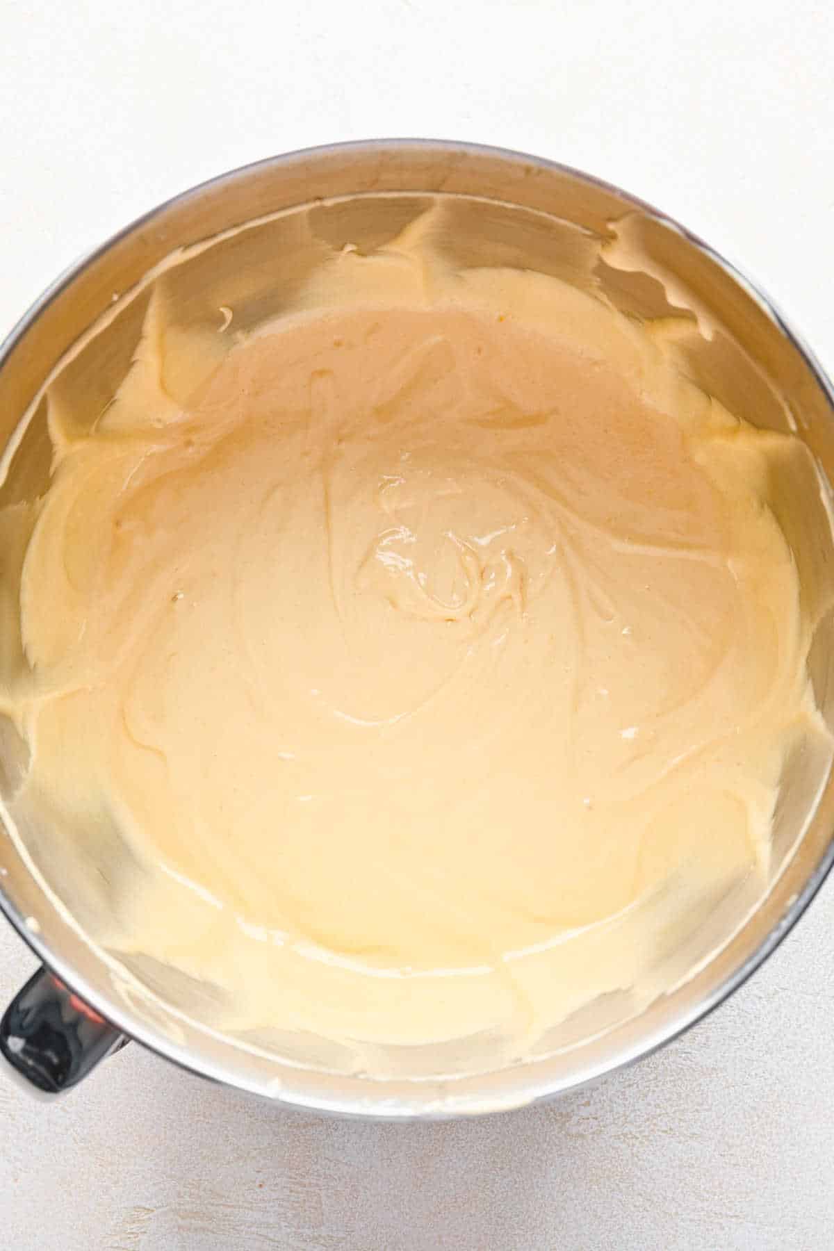 Yellow cake batter in a silver mixing bowl. 