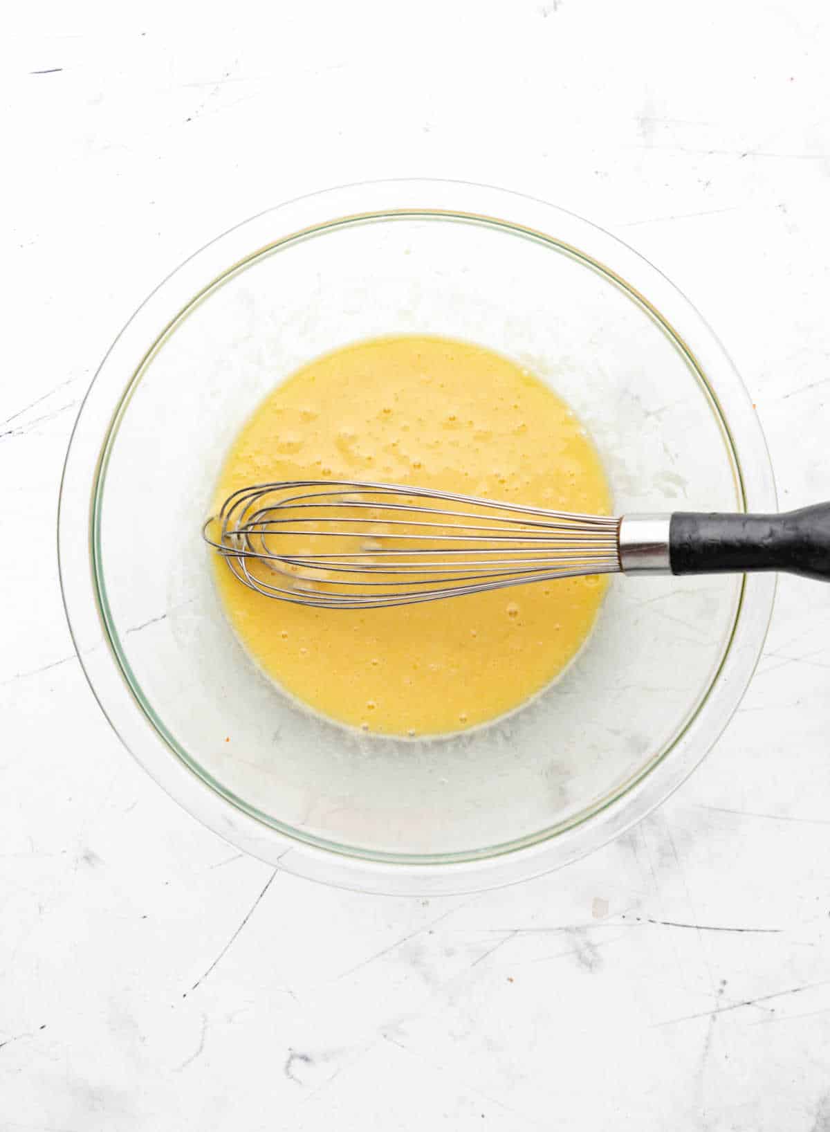 Buttermilk oil and eggs in a glass mixing bowl.