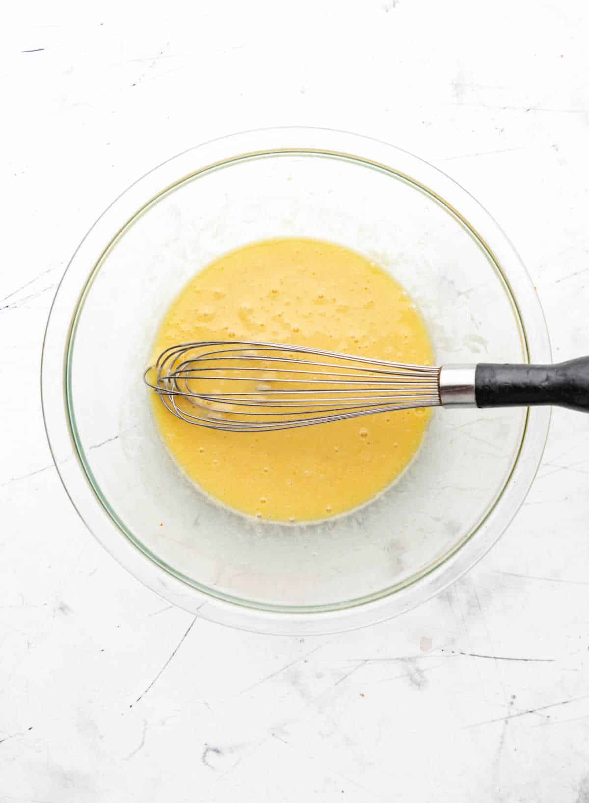 Buttermilk oil and eggs in a glass mixing bowl. 