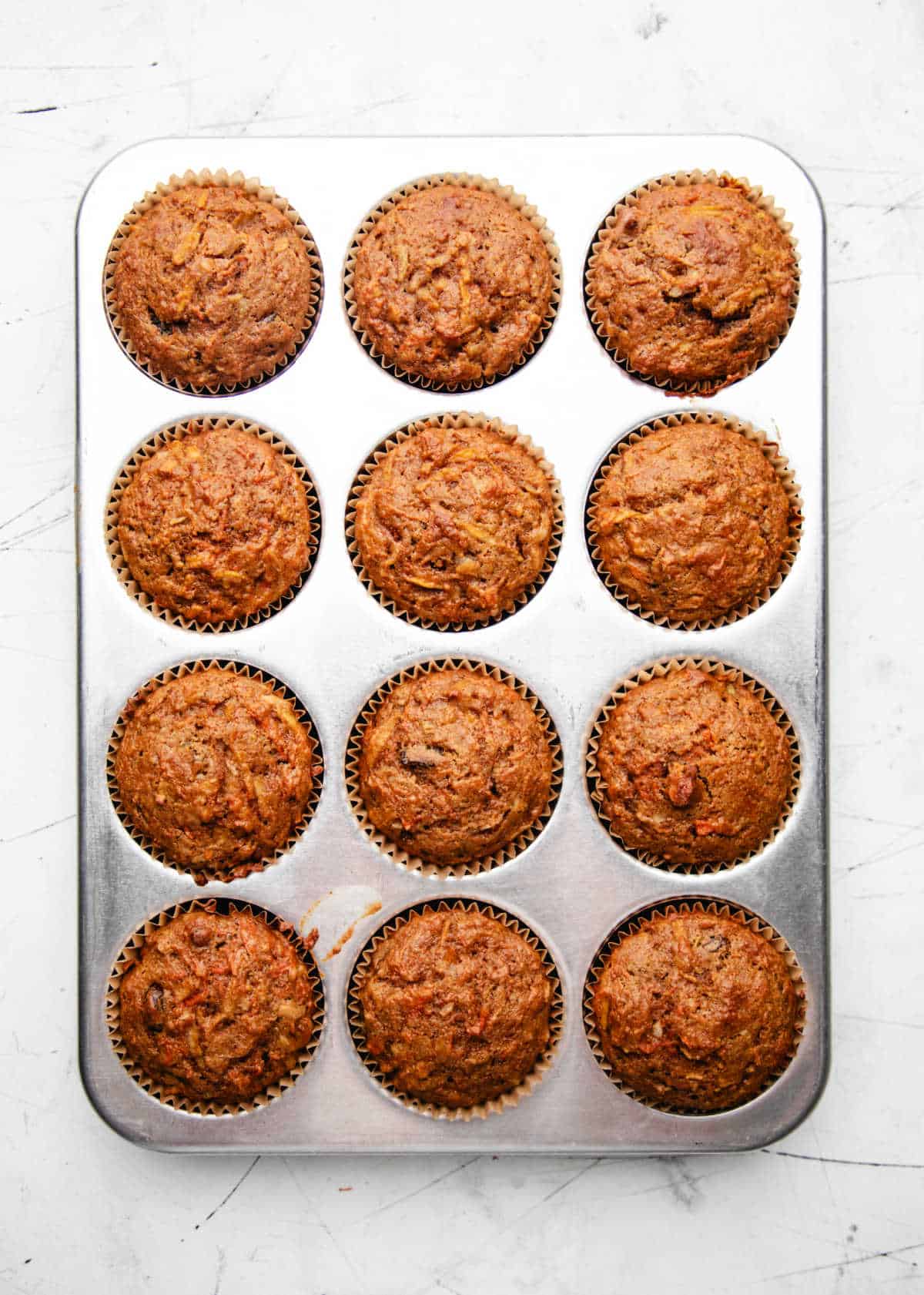 Baked morning glory muffins in a muffin tin.
