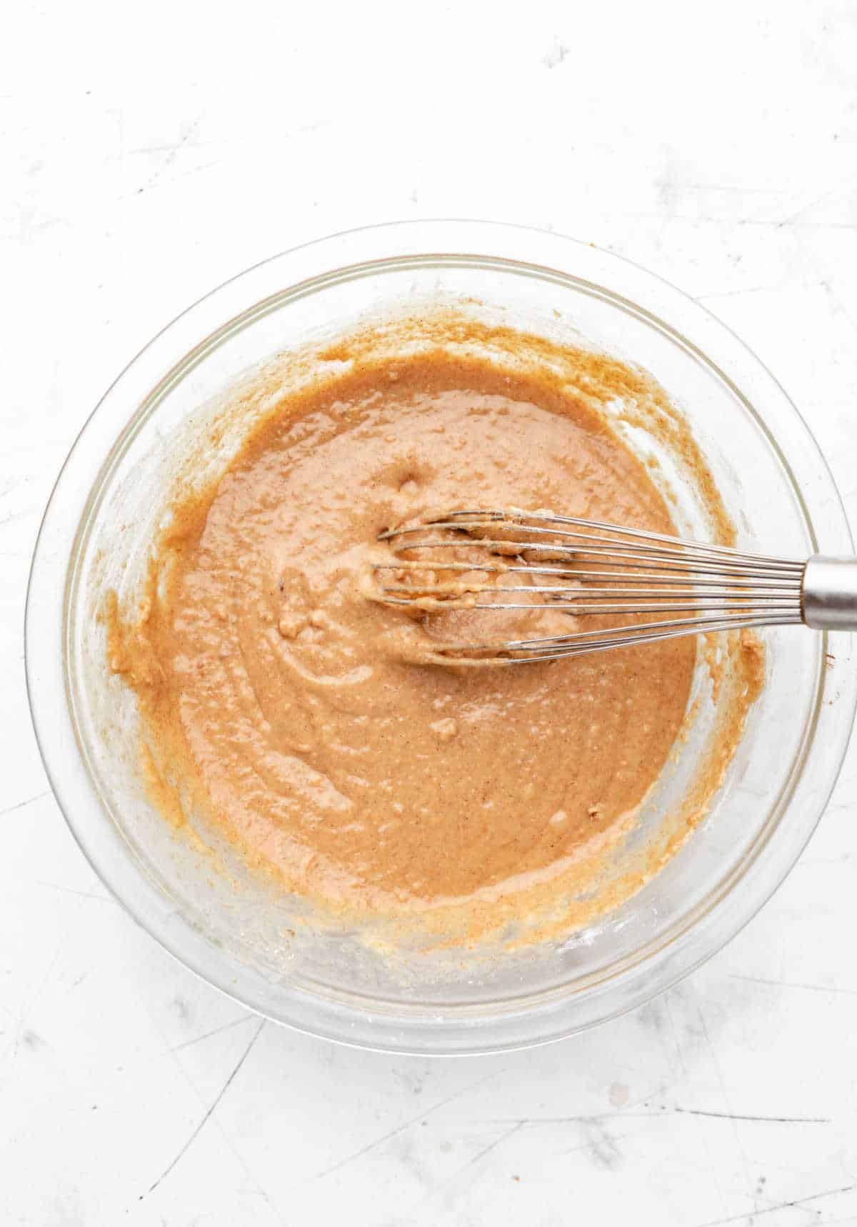 Morning glory muffin batter in a glass mixing bowl.