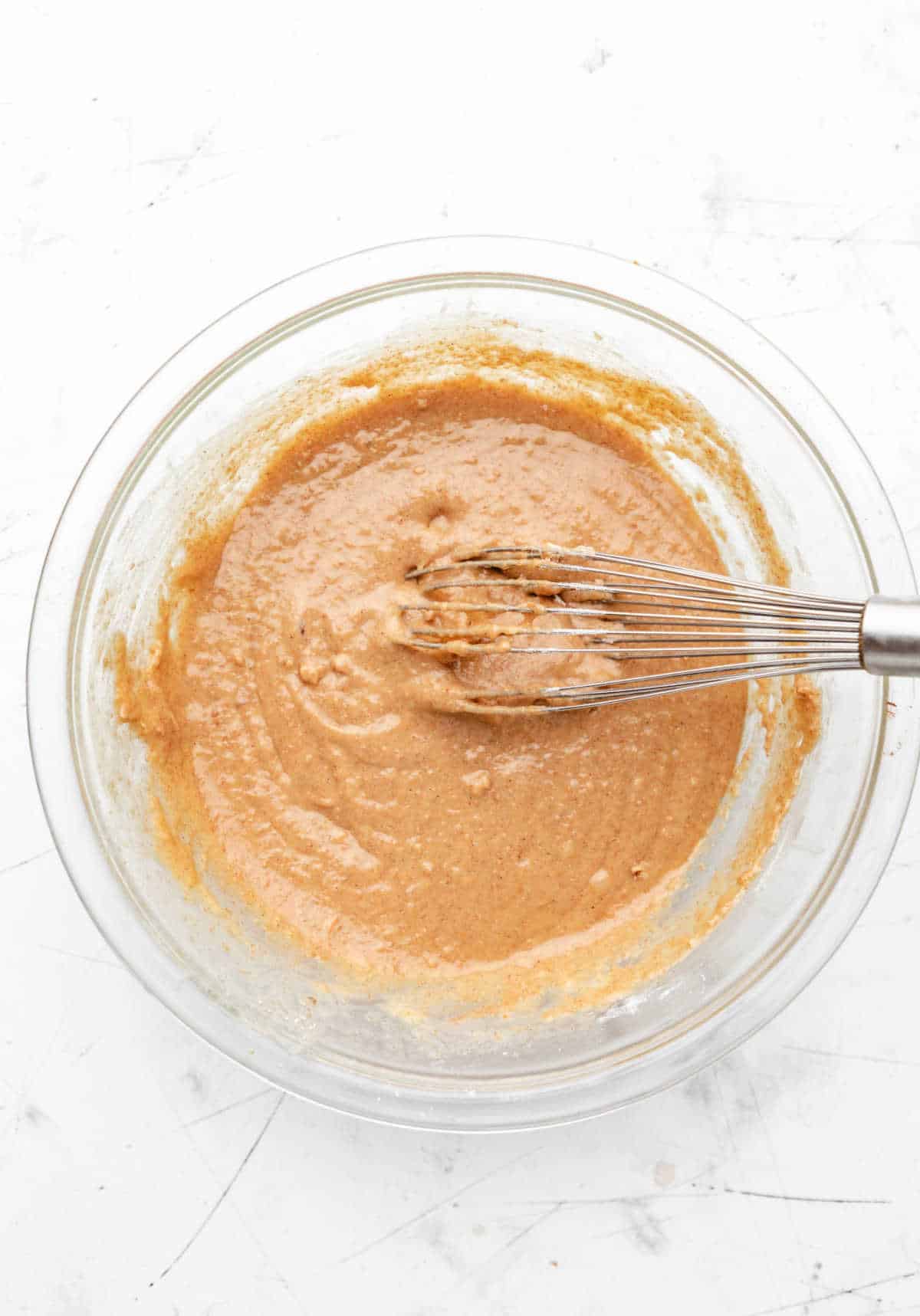 Morning glory muffin batter in a glass mixing bowl. 