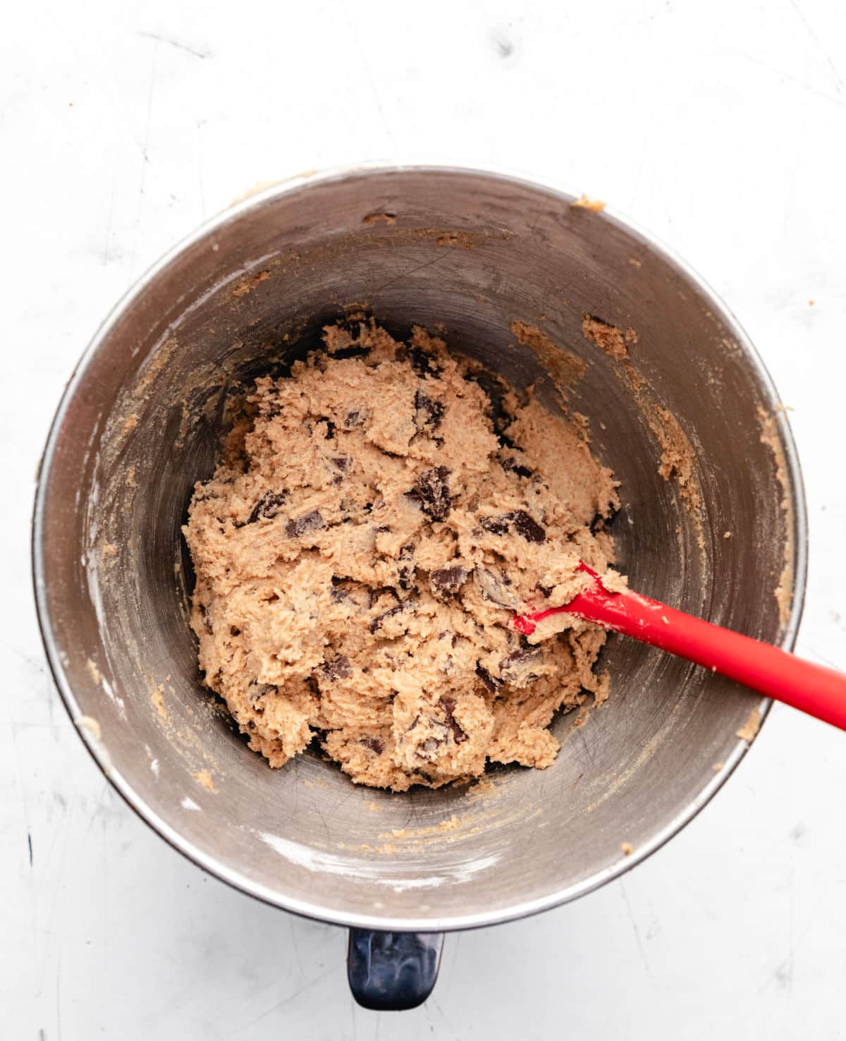 Whole wheat chocolate chip cookie dough in a silver mixing bowl. 
