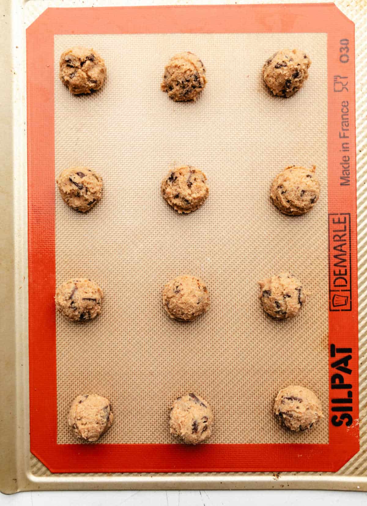 Whole wheat chocolate chip cookie dough on a silicone baking mat.