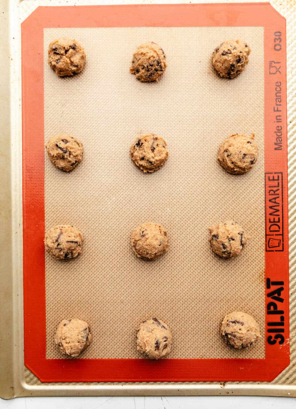 Whole wheat chocolate chip cookie dough on a silicone baking mat. 