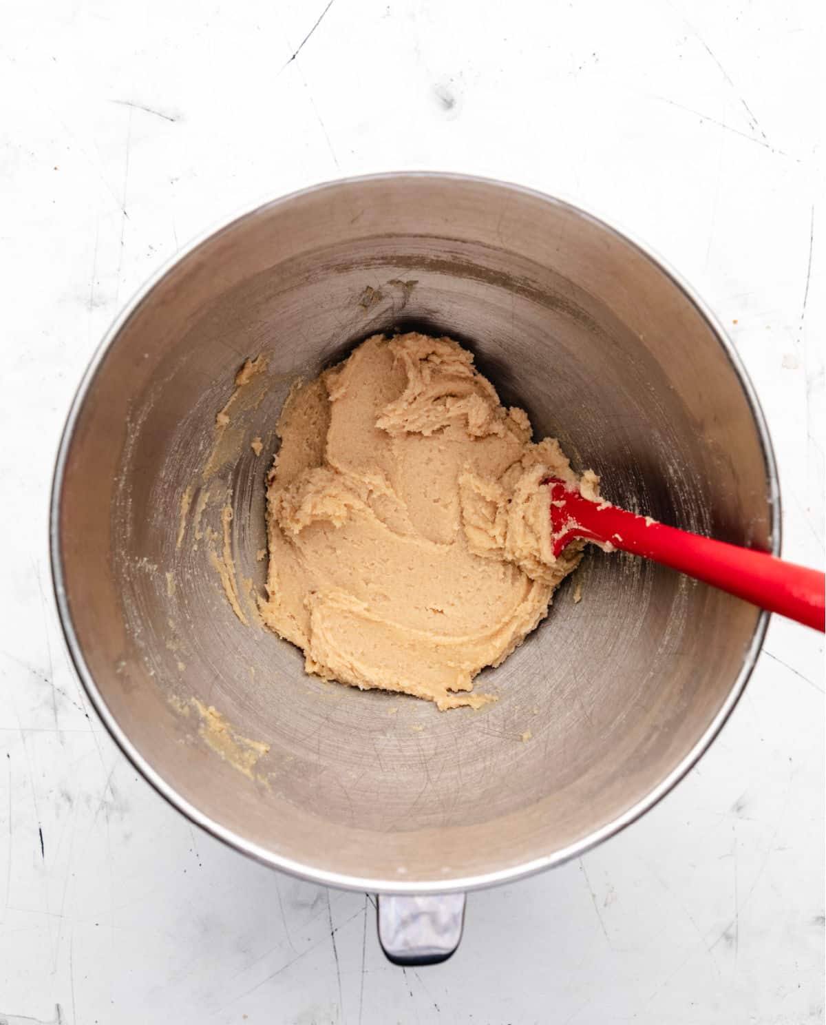 Creamed butter and sugar in a silver mixing bowl.