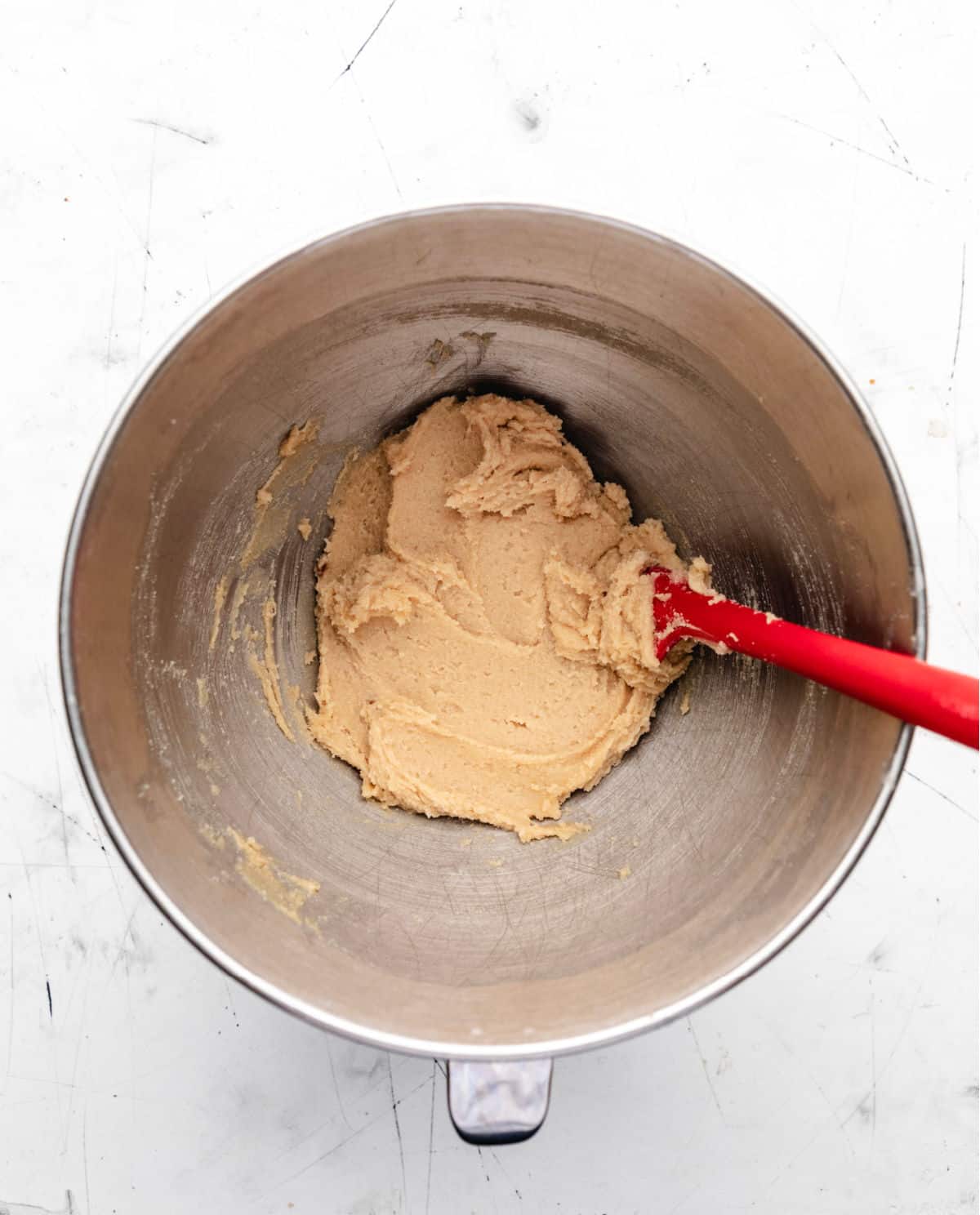 Creamed butter and sugar in a silver mixing bowl. 