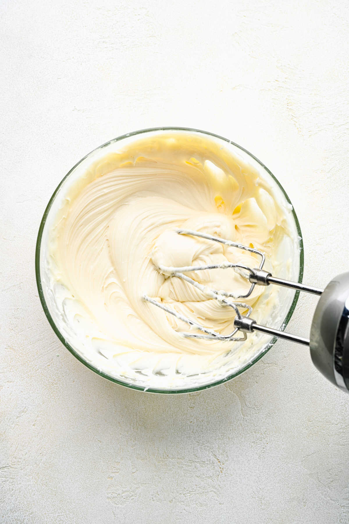 Finished cream cheese frosting  in a glass mixing bowl. 