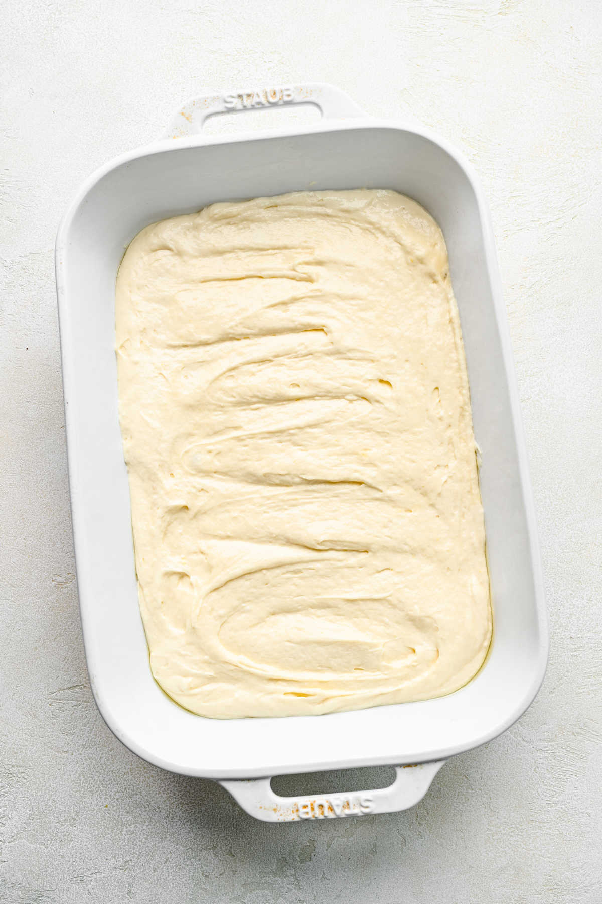 Cinnamon roll poke cake batter in a baking pan.