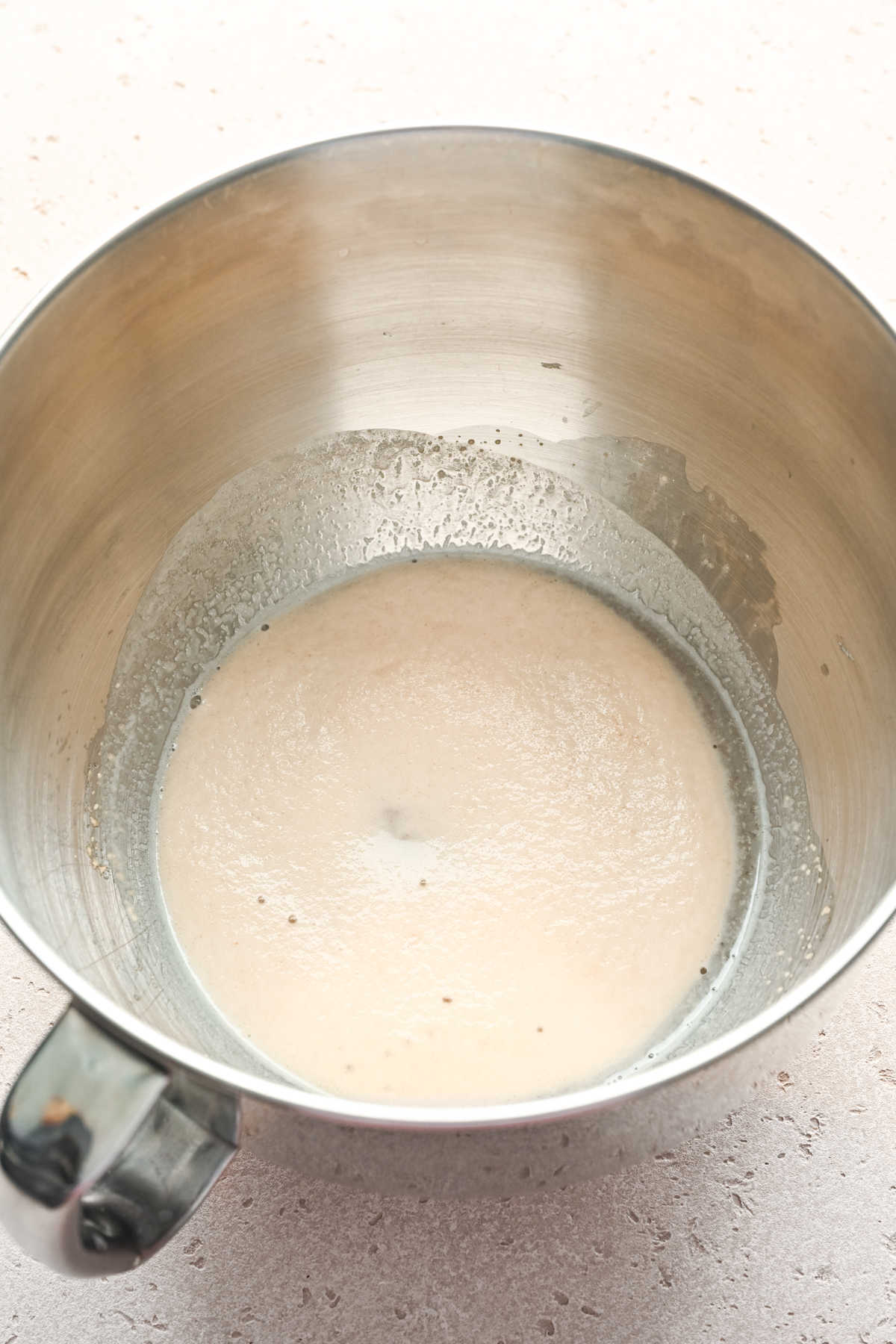 Yeast proofing in a silver mixing bowl. 