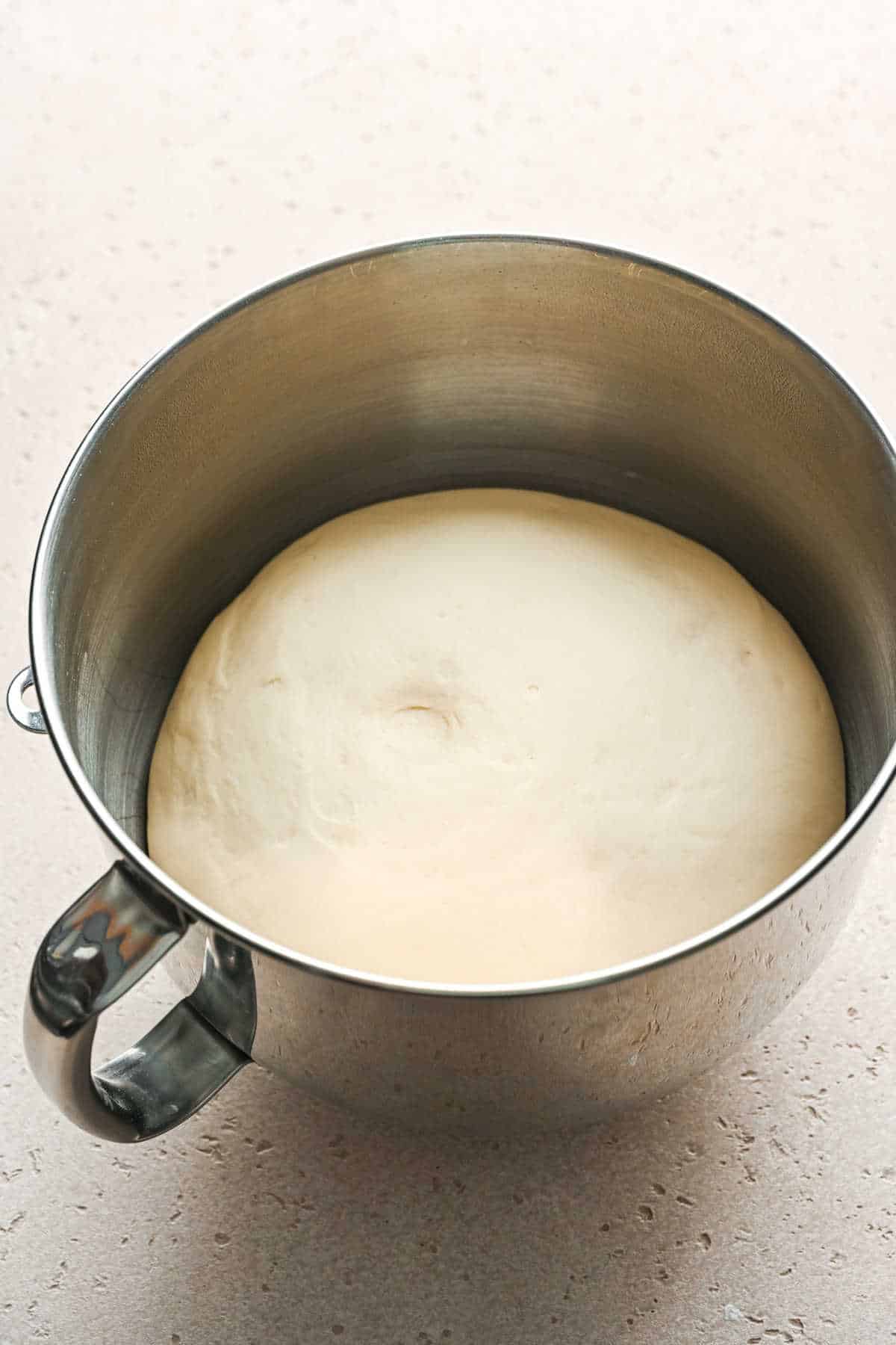 Cinnamon breadstick dough in a silver mixing bowl. 
