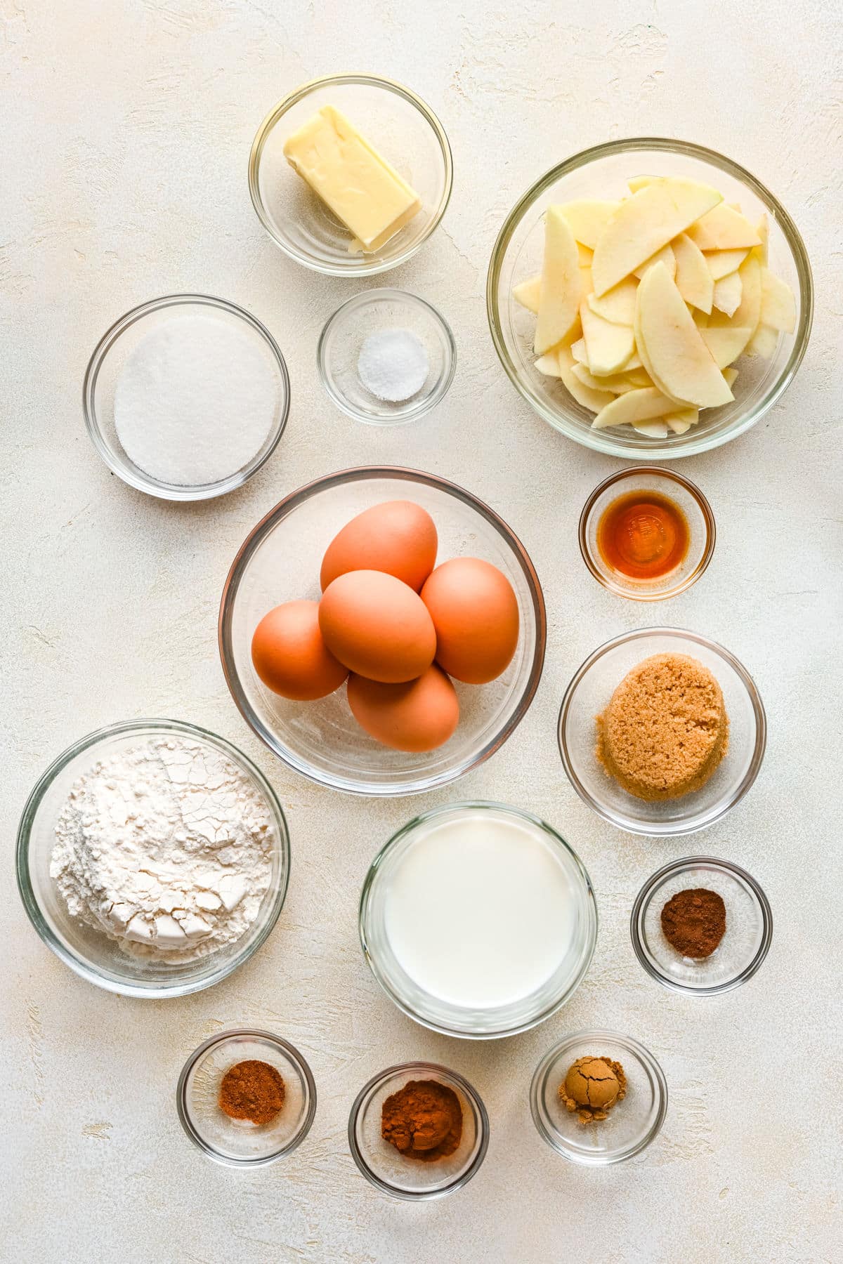 Ingredients for German apple pancake in glass dishes. 