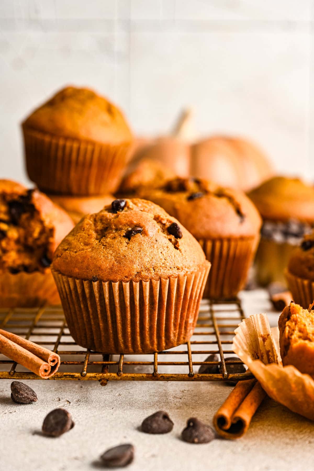 Pumpkin chocolate chip muffins on a wire cooling rack.