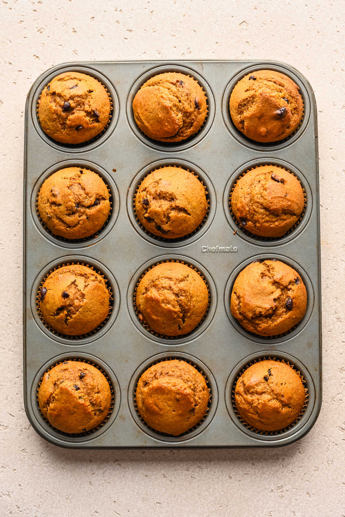 Baked pumpkin chocolate chip muffins in a muffin tin.