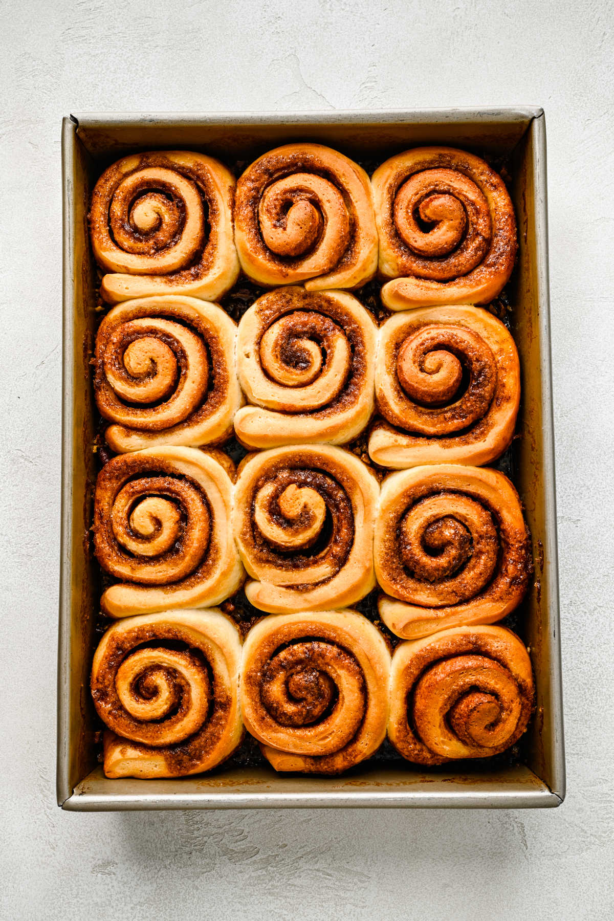 Baked sticky buns in a metal baking pan.