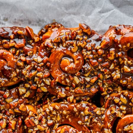 Close up photo of homemade sticky buns on a parchment lined baking tray.