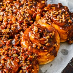 Homemade sticky buns on a parchment lined baking sheet.