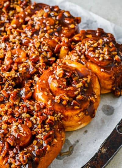 Homemade sticky buns on a parchment lined baking sheet.