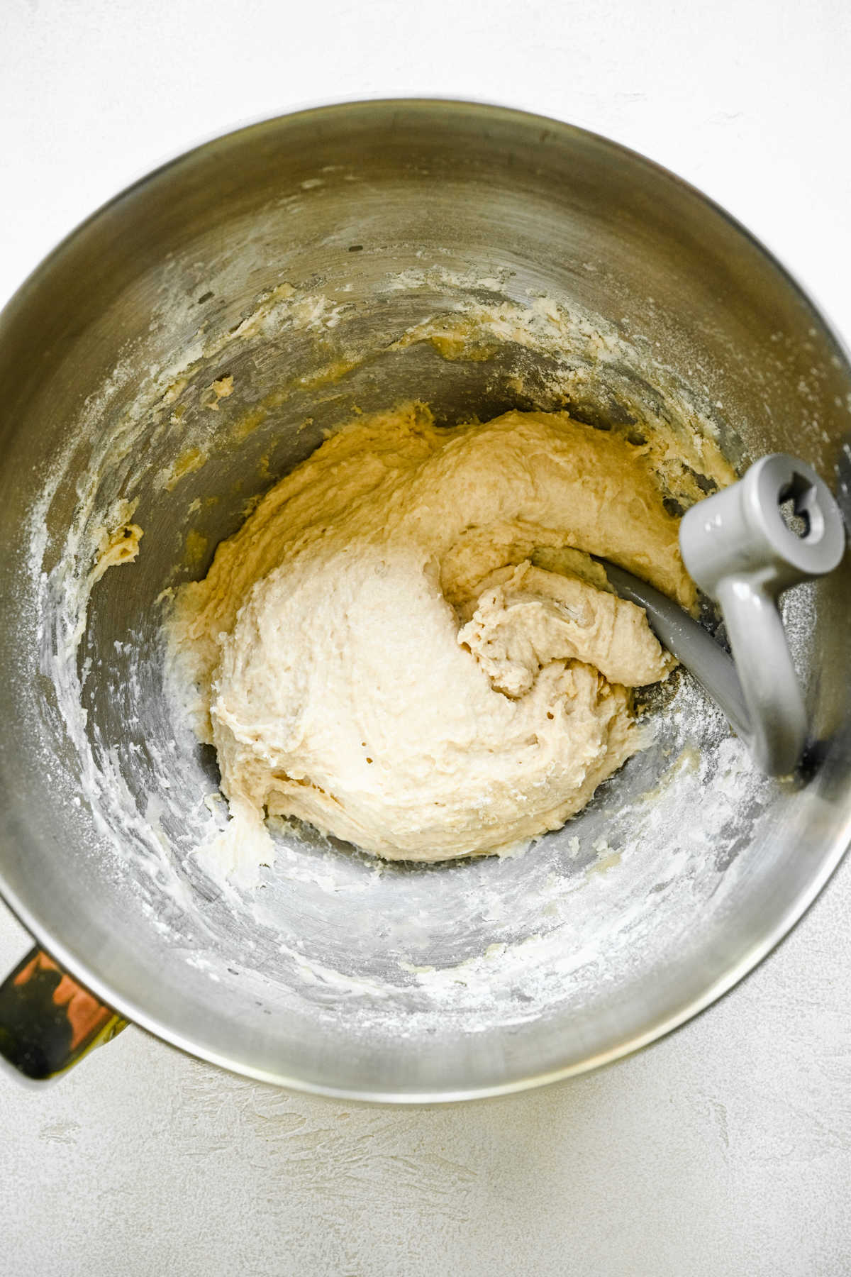 Shaggy sticky bun dough in a silver mixing bowl. 