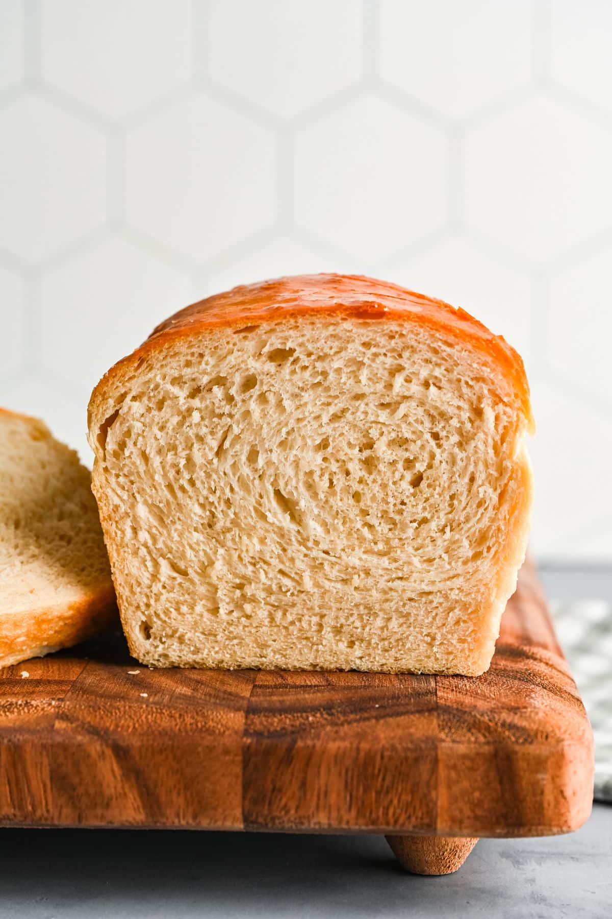 A loaf of homemade white bread with the slices cut off next to it.