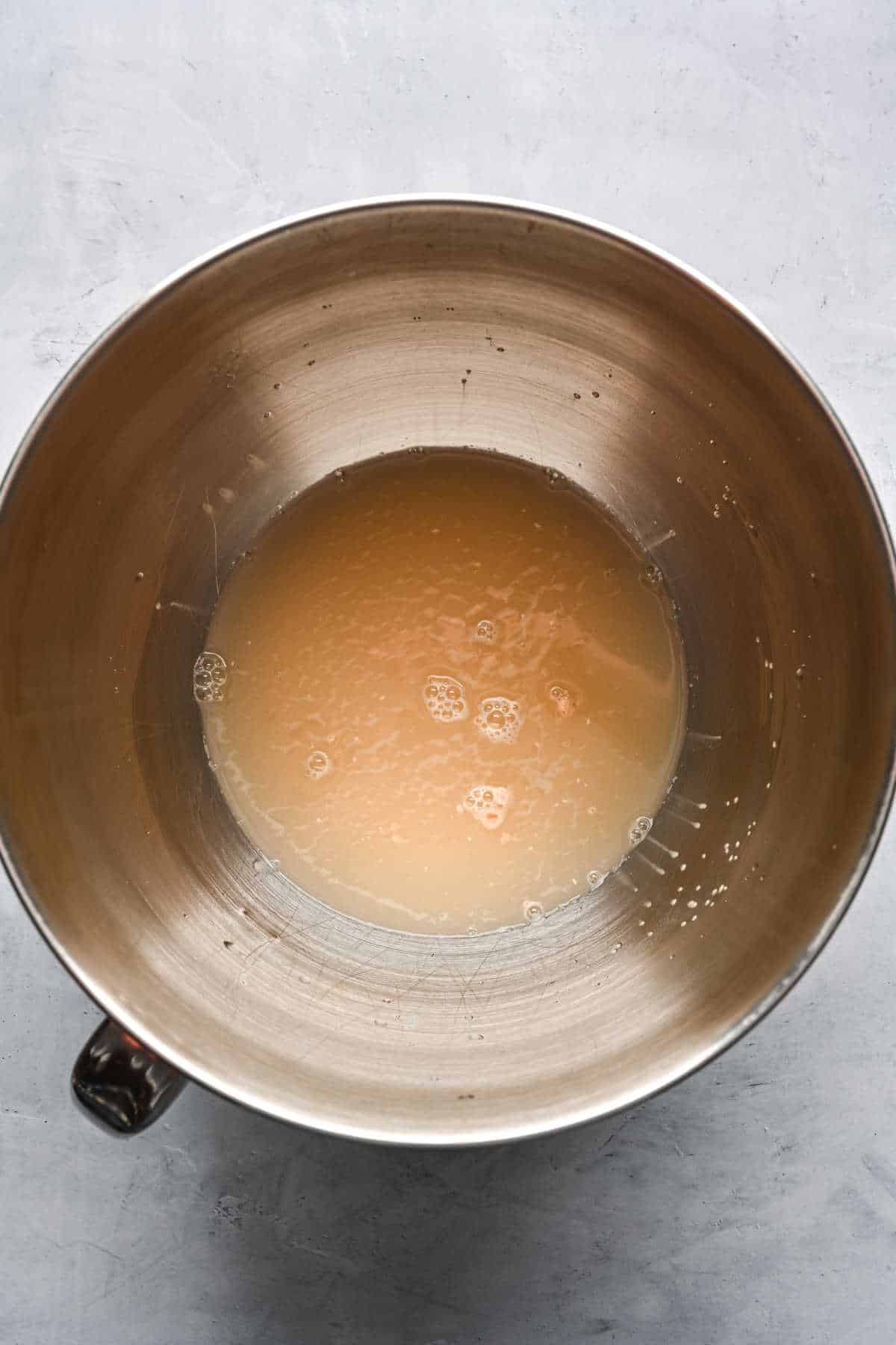 Yeast proofing in a silver mixing bowl. 