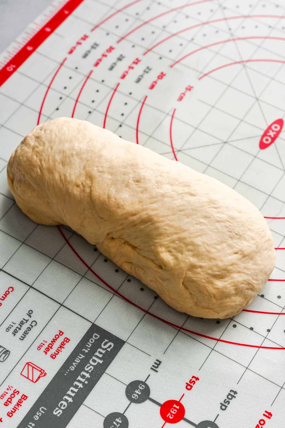 White bread dough rolled into a loaf shape.