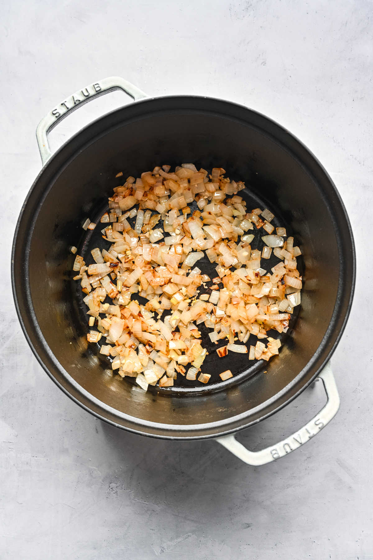 Onion sautéing in butter in a cast iron pot.