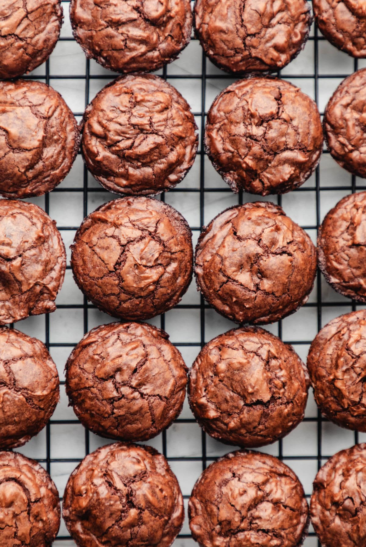 Mini brownie bites cooling on a black wire cooling rack. 