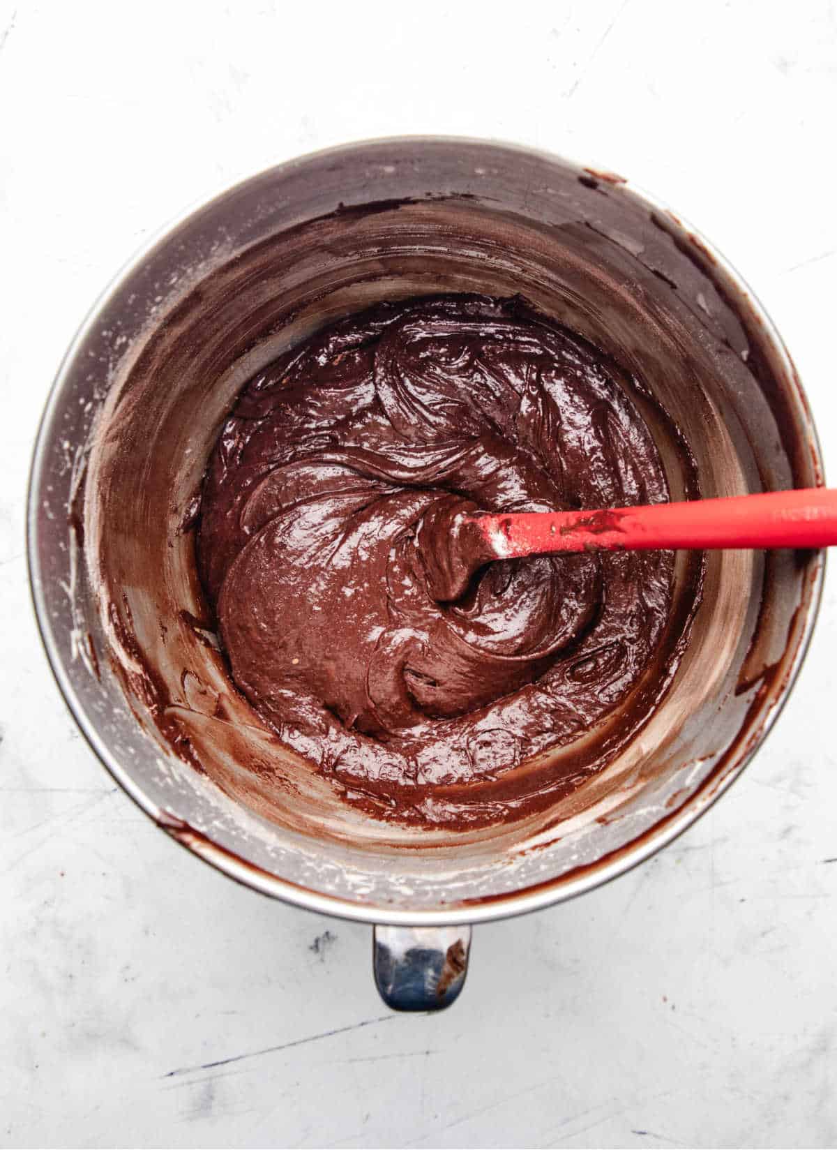 Brownie bite batter in a silver mixing bowl. 