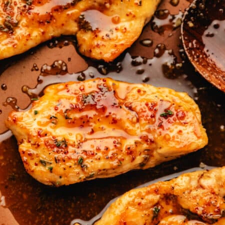 Close up photo of maple mustard chicken breasts in a skillet.