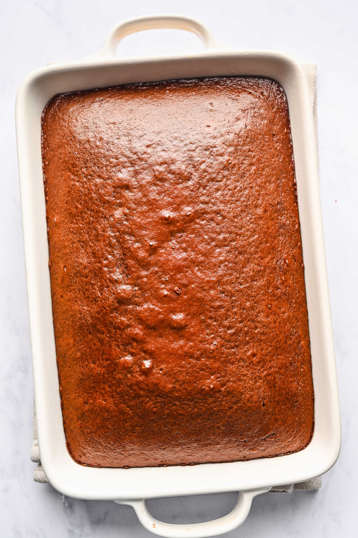 Baked Coca Cola cake in a white baking pan.