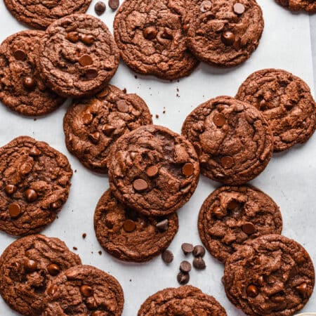 Stacks of overlapping Nutella cookies on a piece of white parchment paper.