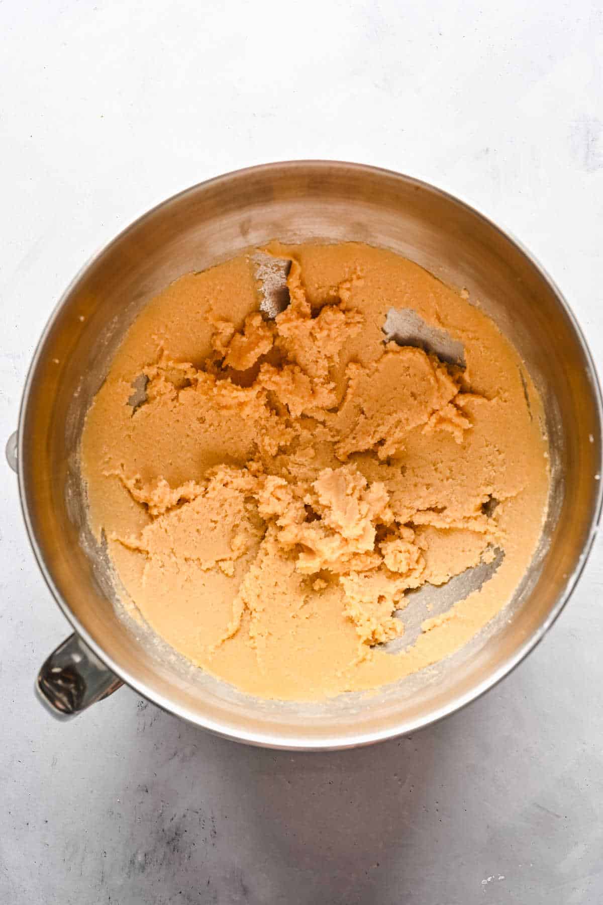 Creamed butter and sugar in a silver mixing bowl. 