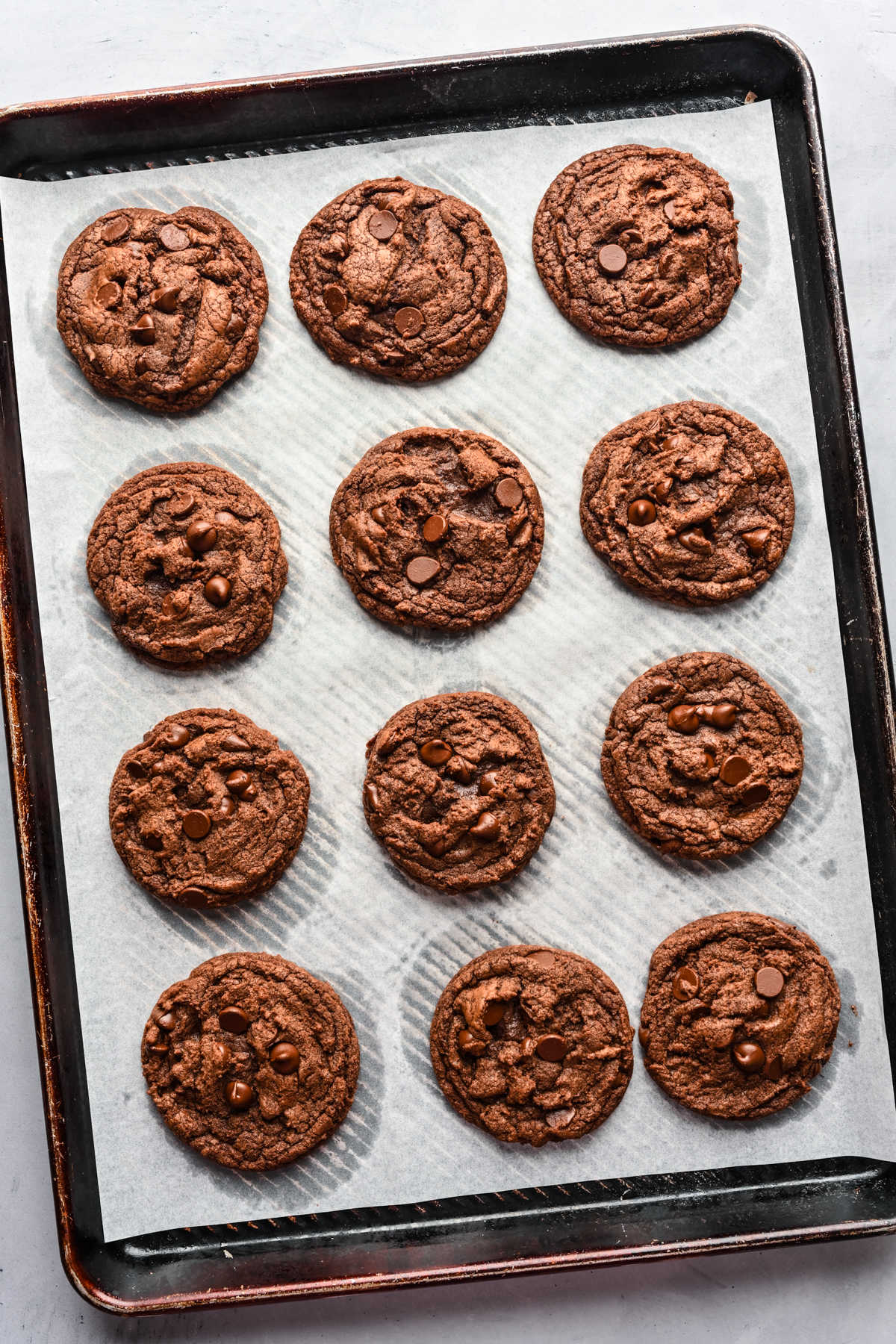 A dozen baked Nutella cookies on a cookie sheet.