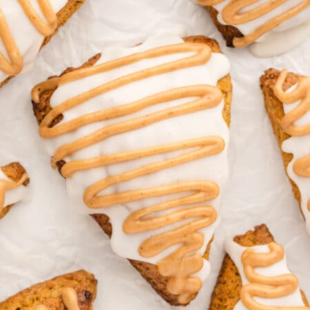 Pumpkin scones on a piece of white parchment paper.