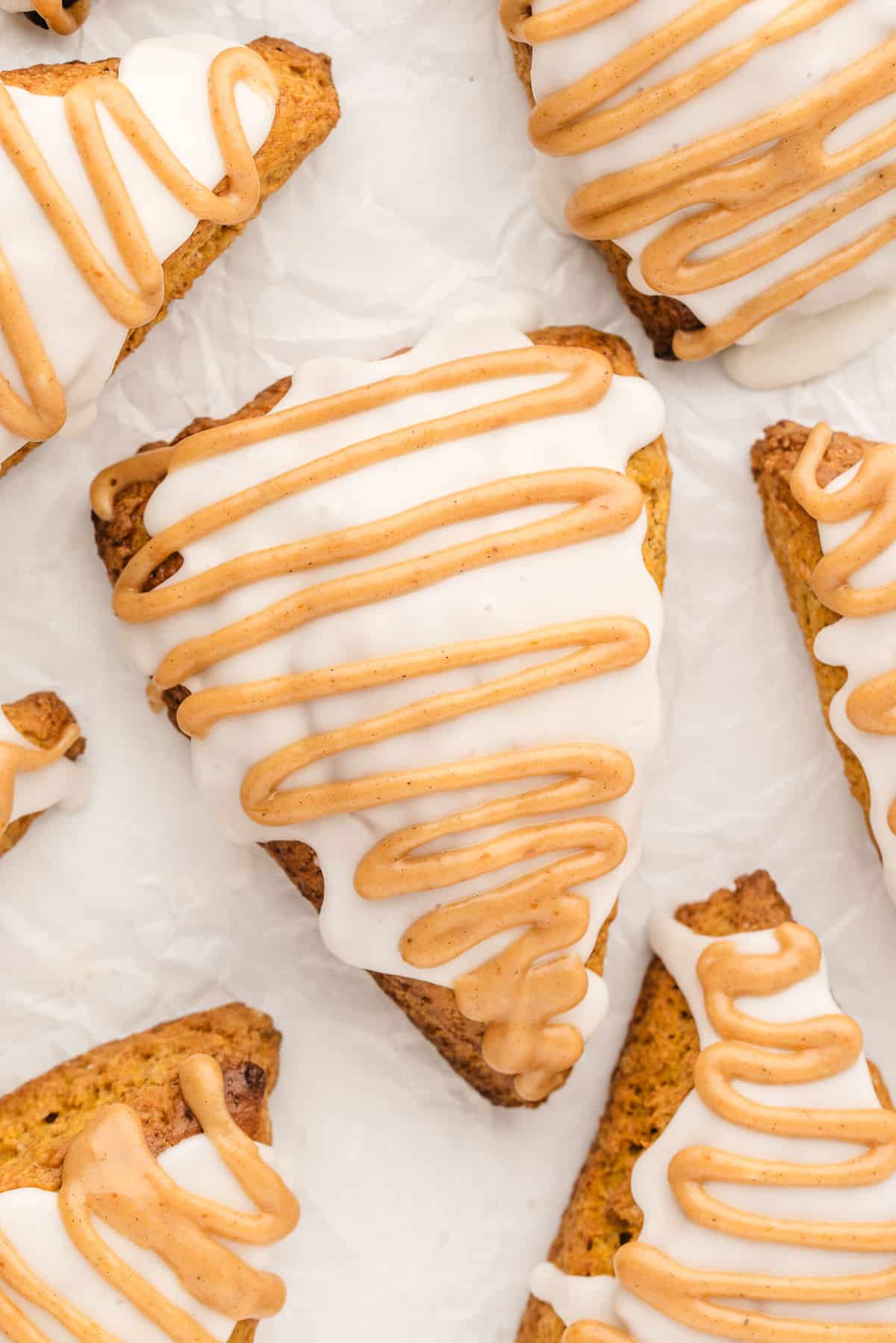 Pumpkin scones on a piece of white parchment paper. 