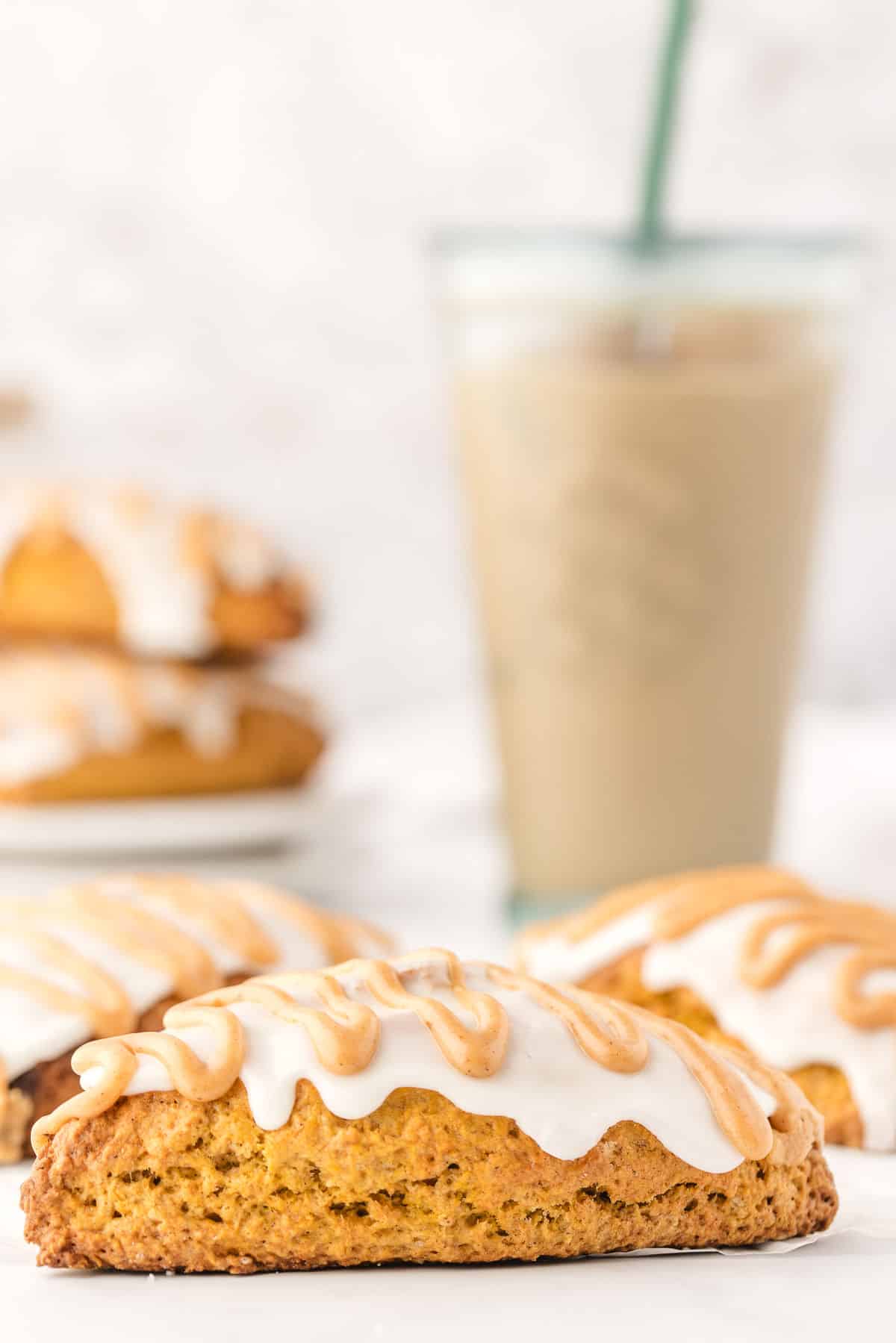 Pumpkin scones in front of a cup of iced coffee.