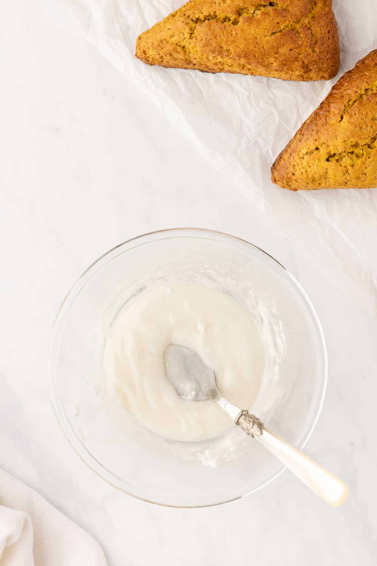 A bowl of glaze with a spoon in it. 