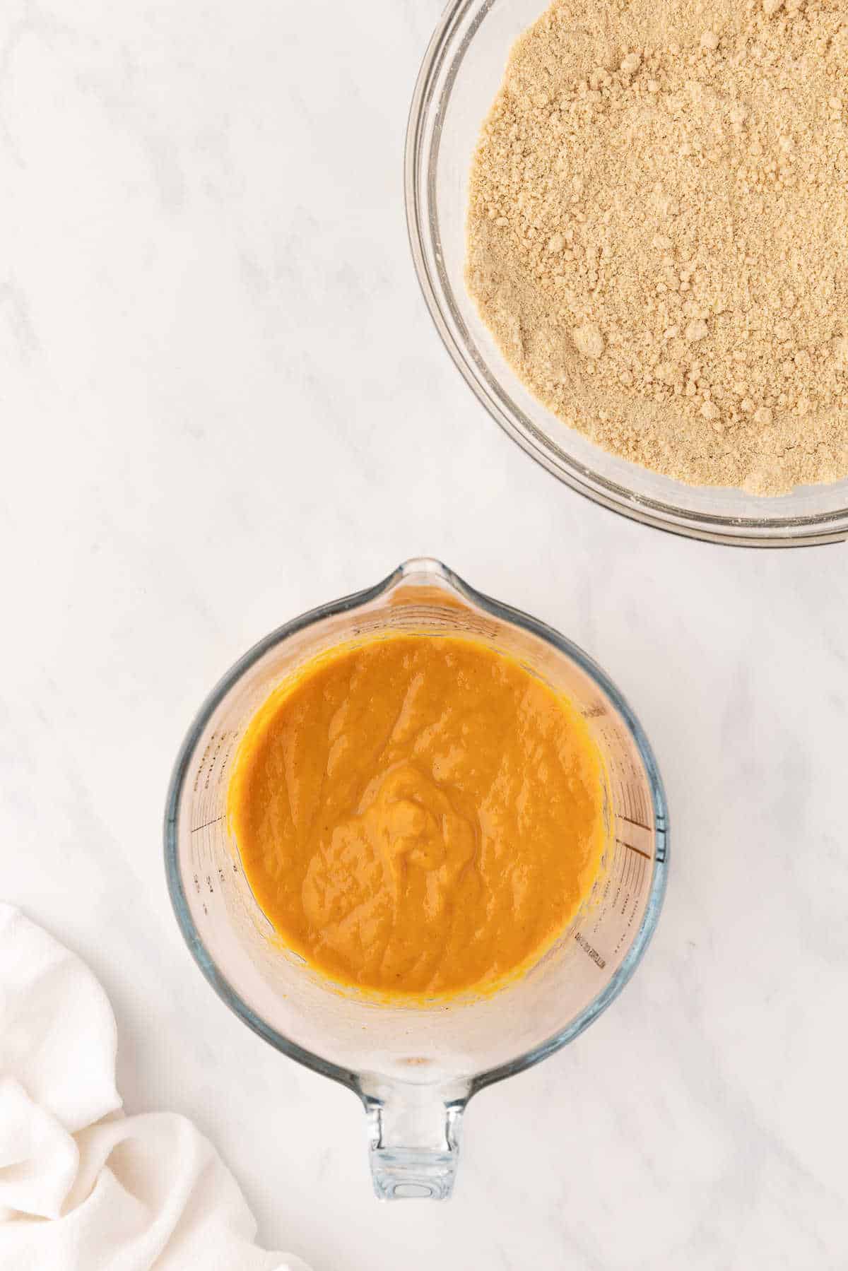 Wet ingredients in a glass mixing bowl for pumpkin scones.