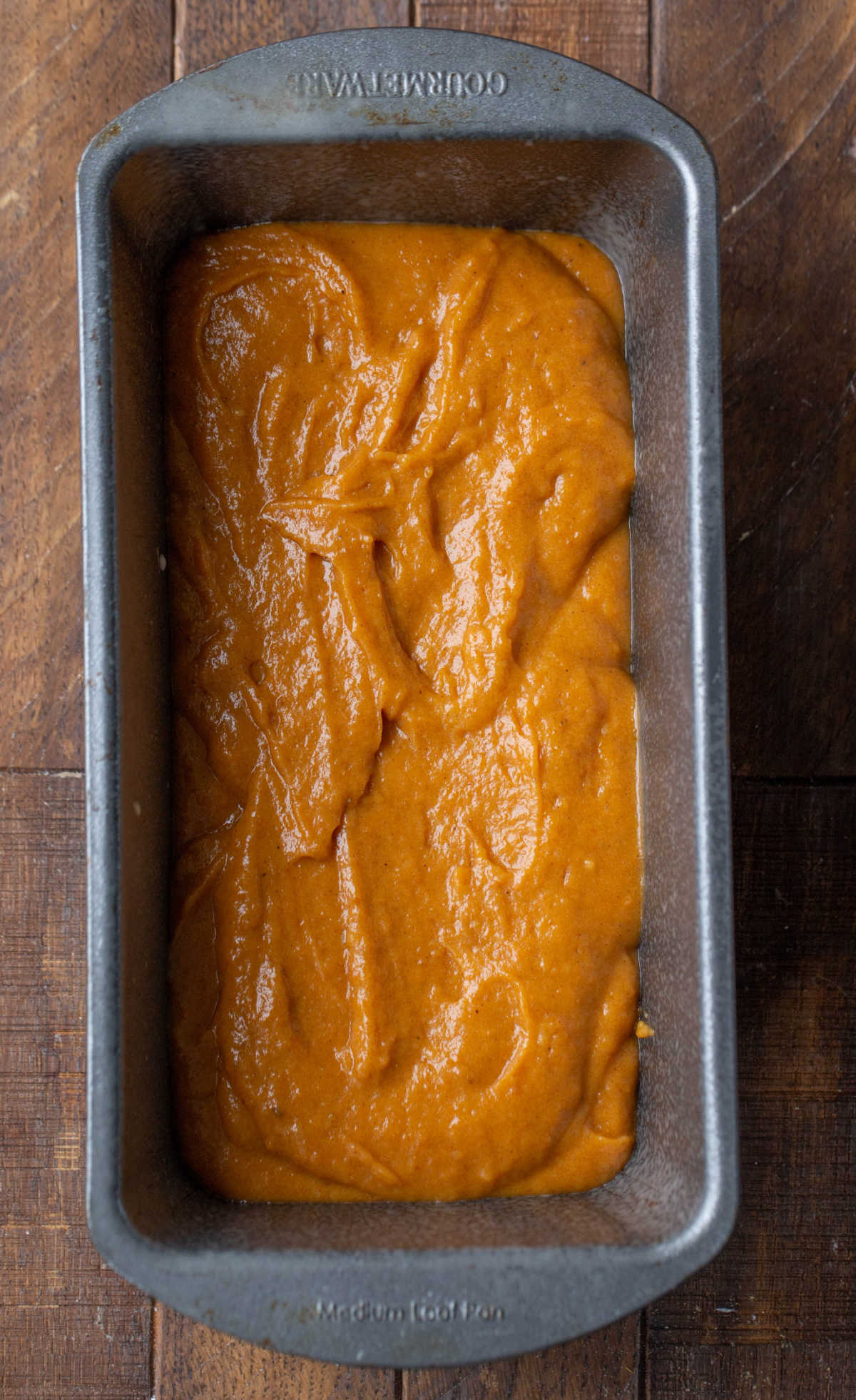 Pumpkin bread batter in a silver bread pan.