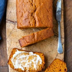 Sliced pumpkin bread on a marble cutting board.