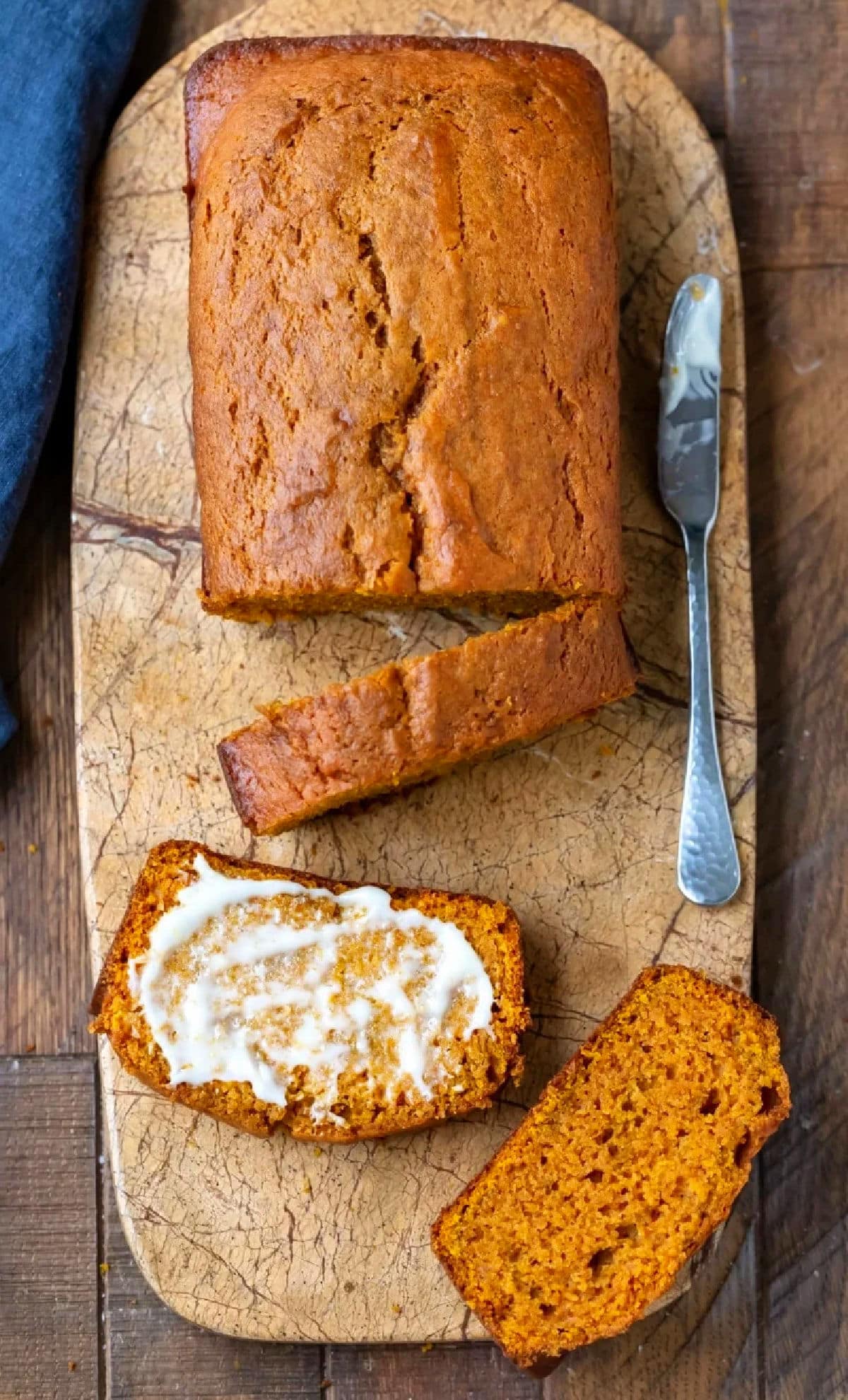 Sliced pumpkin bread on a marble cutting board.