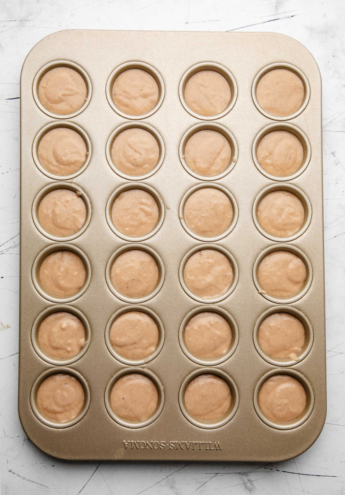 Apple cider donut hole batter in a mini muffin pan.